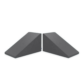 Image of two dark gray Mega Wedge Play Triangles from Foamnasium, positioned side by side. The wedges have a sloped design for sliding under doors to keep them open or secure, crafted from durable foam playset materials and GREENGUARD GOLD Certified for safety.